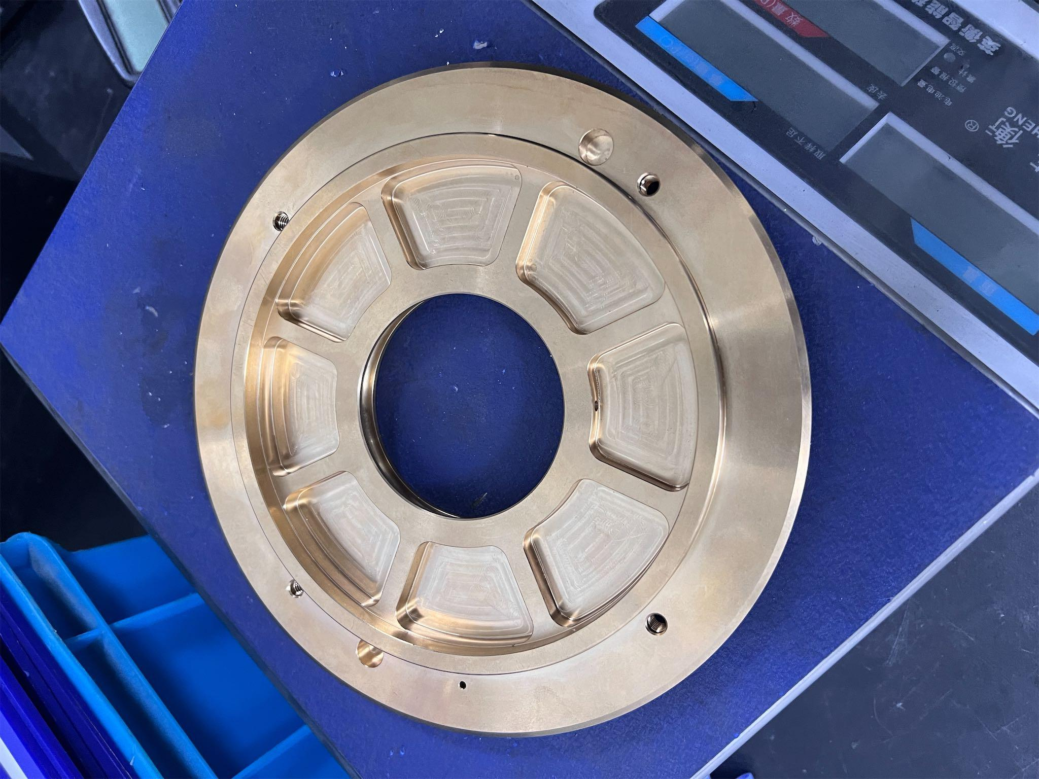 Large annular brass CNC machined component with stepped face and central bore