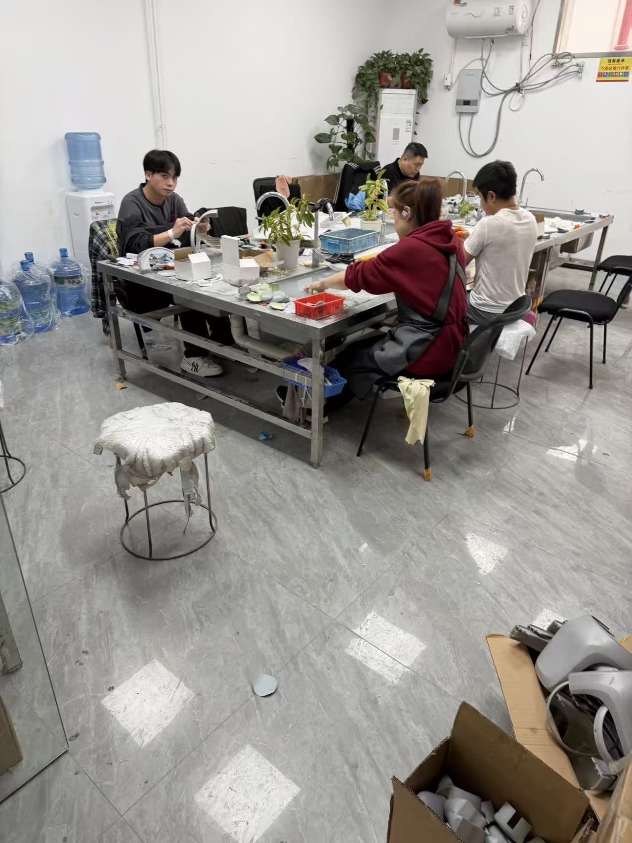 Zhenling team performing manual surface finishing work on metal parts