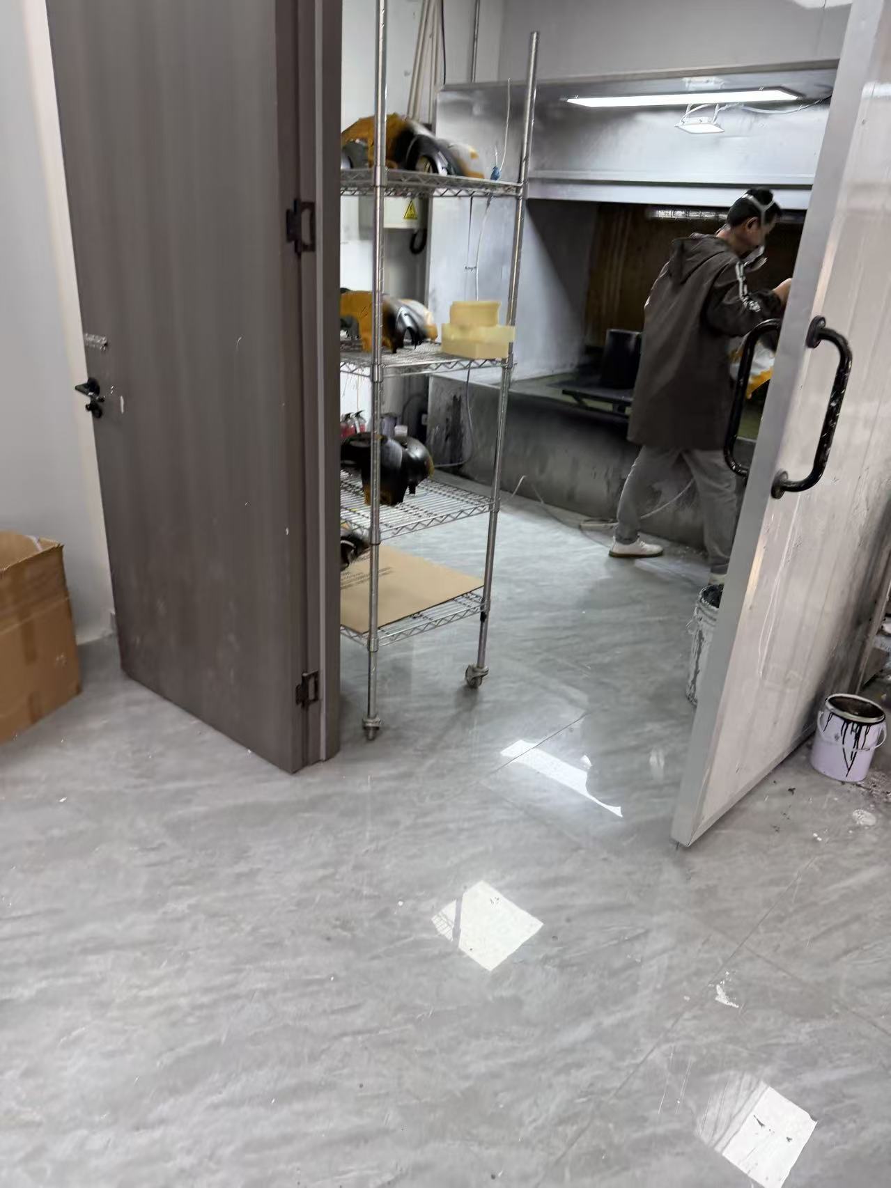 Zhenling operator working inside a real surface finishing booth in the Jiashan workshop